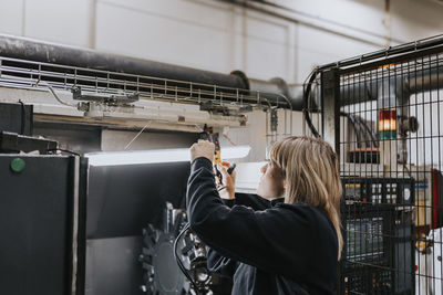 Female electrician doing measurements at work