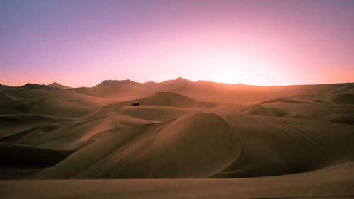 Scenic view of desert against sky during sunset