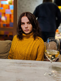 Beautiful young woman sitting on table