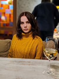 Beautiful young woman sitting on table