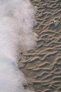 High angle view of footprints on sand at beach