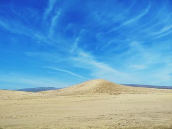 Scenic view of desert against blue sky