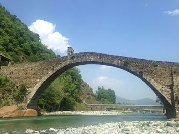 Bridge over river against cloudy sky