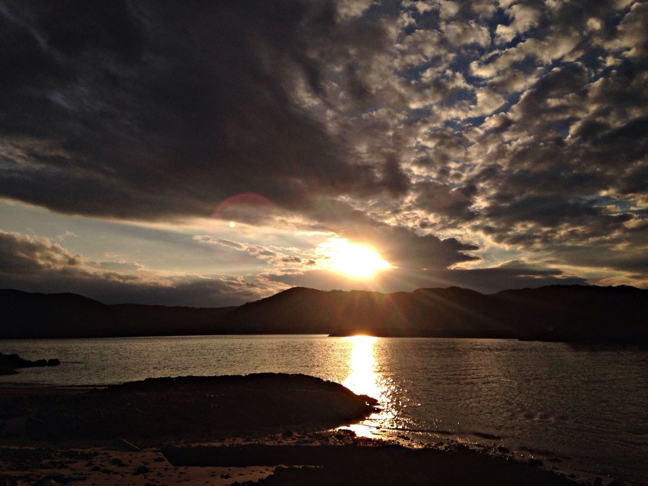 water, sunset, sun, sky, scenics, tranquil scene, mountain, beauty in nature, tranquility, cloud - sky, silhouette, reflection, nature, mountain range, sunbeam, sunlight, idyllic, sea, lake, cloud