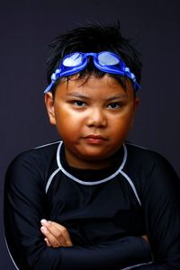 Close-up portrait of boy against black background