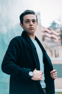 Portrait of young man standing against sky