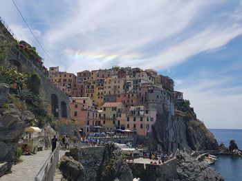 Buildings by sea against sky in city