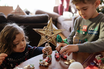 Two young boys playing with christmas decorations at home