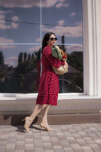 Young woman standing against window