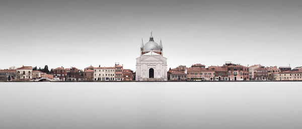 Buildings by river in city