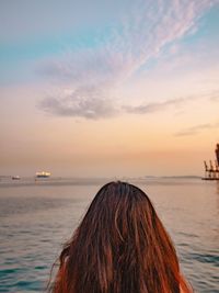 Close-up of woman at sea at sunset