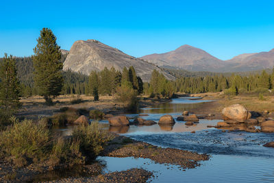 Scenic view of lake and mountains against clear blue sky