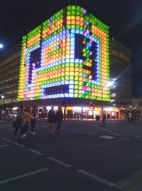 People on illuminated street at night