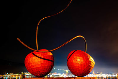 Low angle view of illuminated lanterns against sky at night