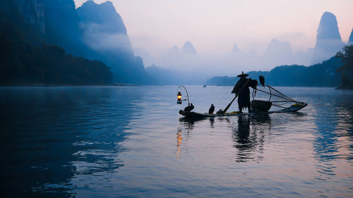 People on boat in sea against sky