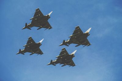 Low angle view of fighter planes flying against sky