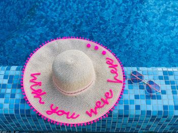 High angle view of sun hat with text at swimming pool