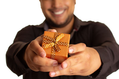 Midsection of man holding ice cream against white background