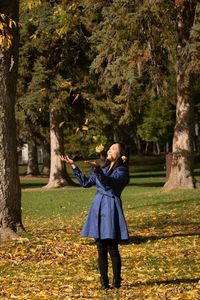 Woman standing on tree trunk