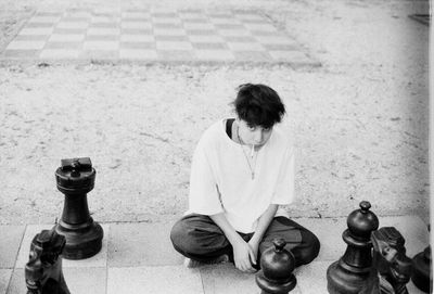 High angle view of man sitting on chess board