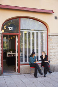 Full length of mid adult businesswomen discussing outside office