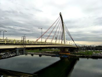 Golden gate bridge over river against cloudy sky