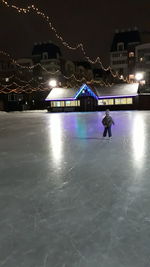 Person in illuminated city at night during winter