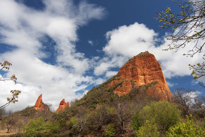 Low angle view of rock formation against cloudy sky