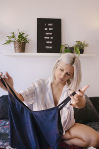 Midsection of woman holding mask at home