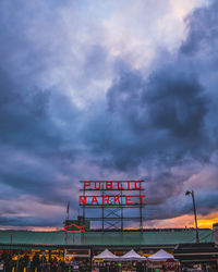 Low angle view of illuminated sign against sky