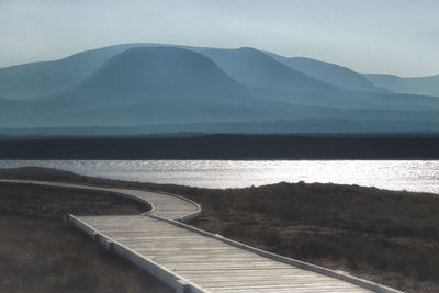 Scenic view of sea and mountains against sky