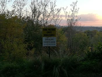 Information sign on grass against sky