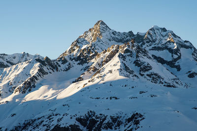 Scenic view of snowcapped mountains against clear sky