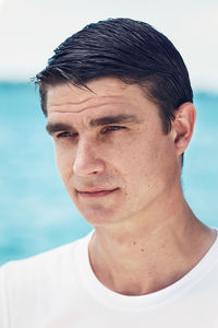 Close-up of man looking away against sea