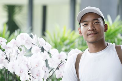 Portrait of man wearing cap by flowers