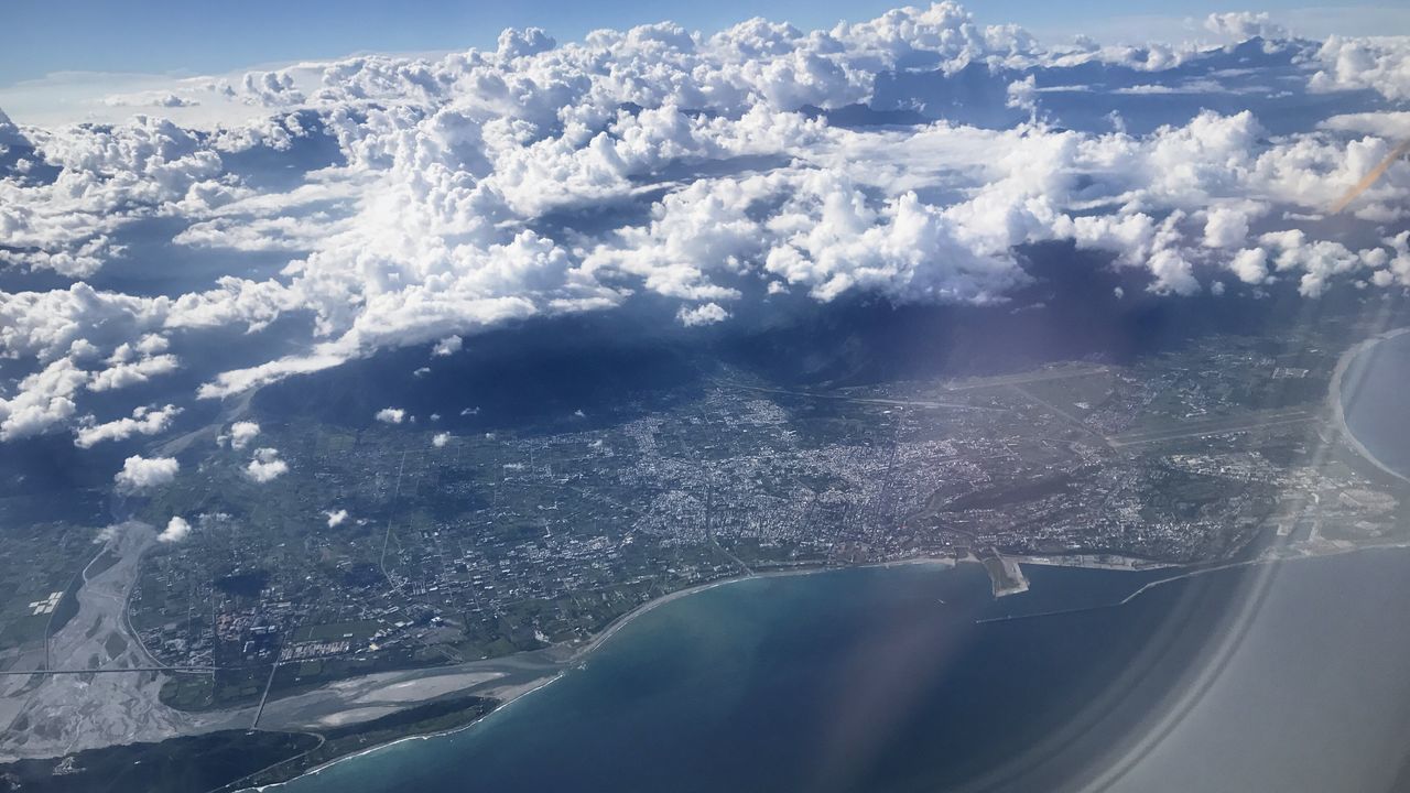 CLOSE-UP OF AIRPLANE FLYING OVER SEA