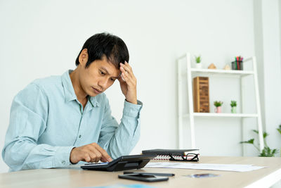 Man looking at camera while sitting on table