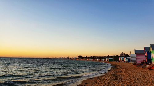 Scenic view of beach against clear sky during sunset