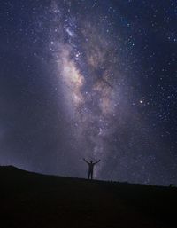 Silhouette person standing on field against sky at night