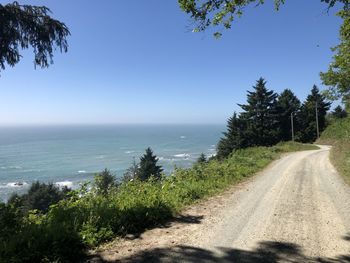 Road by sea against clear sky