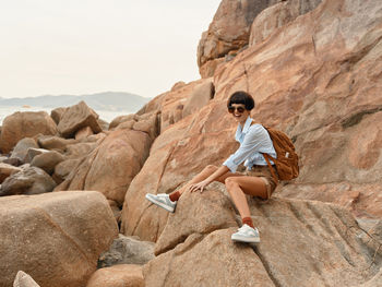 Woman sitting on rock at beach