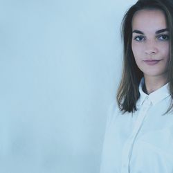 Portrait of young woman against white background