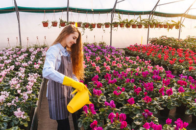 Woman standing by flowering plants