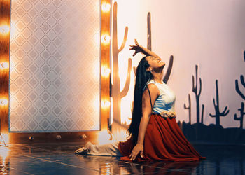 Smiling woman dancing on illuminated stage