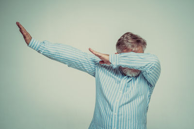 Rear view of man standing against white background