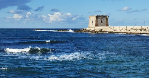 Scenic view of sea and building against sky