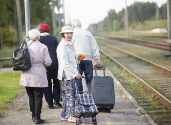 Group of seniors elderly old people with luggage waiting for a train to travel