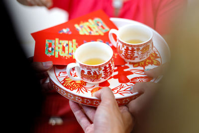 Midsection of woman holding tea cup on table