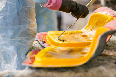 Midsection of man painting chair in factory