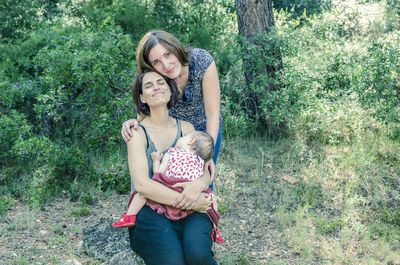 Full length portrait of happy mother and daughter in park